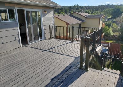 Photo of a freshly installed Trex Deck with black fortress railing with stairs and landing.