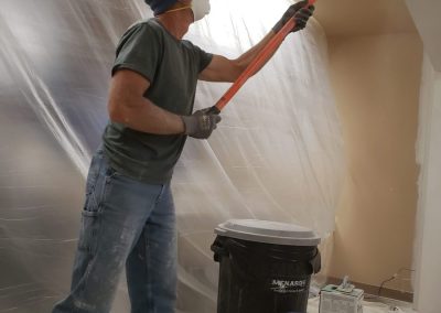Photo of Dean prepping drywall for painting.