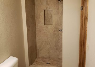 Photo of a newly remodeled tiled shower in a small bathroom.