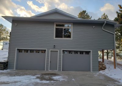 Photo after the new LP Smart siding was installed with new garage doors, window, and transom.