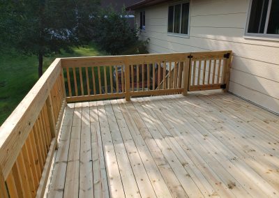 Photo of a wood deck with wooden railing.