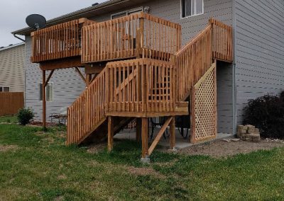 Photo of completed multi-level deck, with wrap-around stairs.