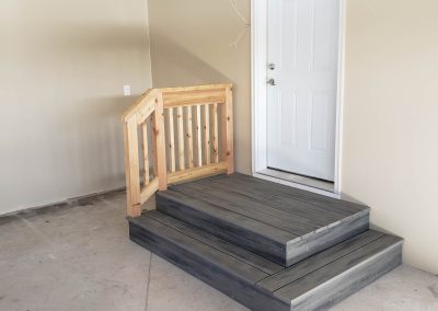 Photo of custom steps and wooden handrail for garage.